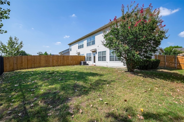 view of yard with central air condition unit and a fenced backyard