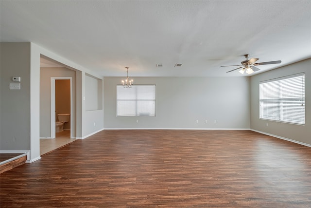 spare room featuring ceiling fan with notable chandelier and hardwood / wood-style flooring