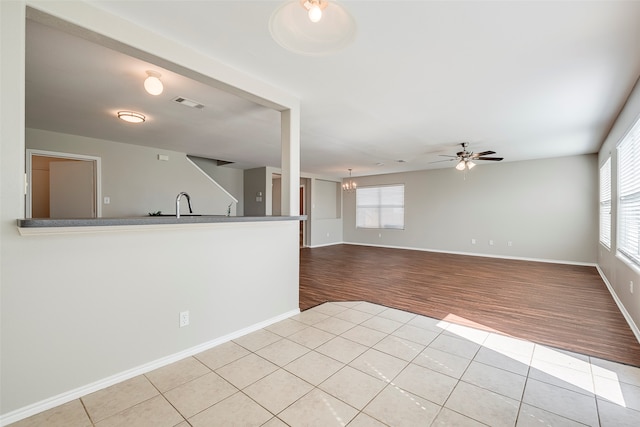 interior space featuring sink, ceiling fan with notable chandelier, and light tile patterned floors