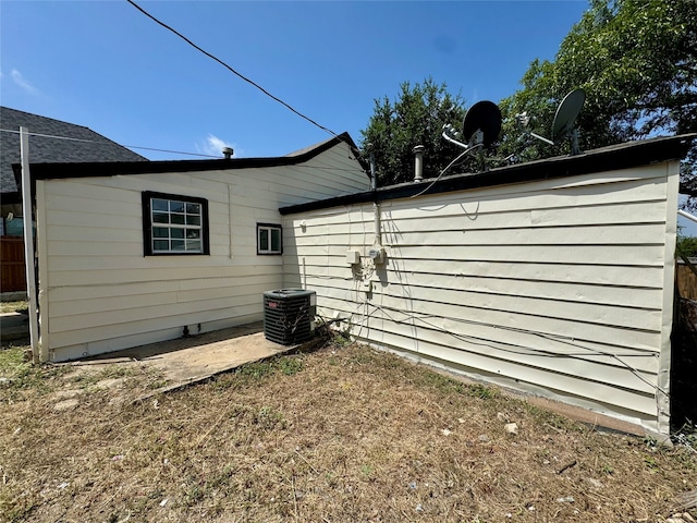 rear view of property with central AC