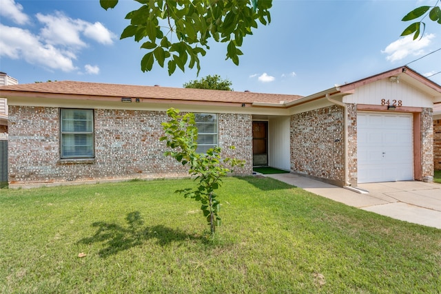 ranch-style home with a garage and a front lawn