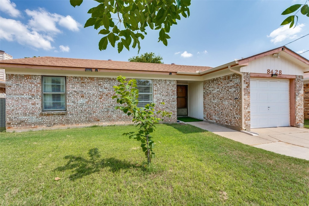 ranch-style home with a garage and a front yard