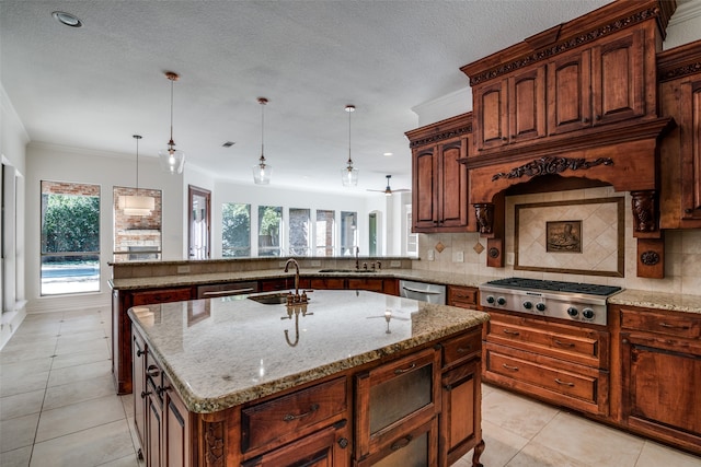 kitchen featuring hanging light fixtures, tasteful backsplash, and a center island with sink