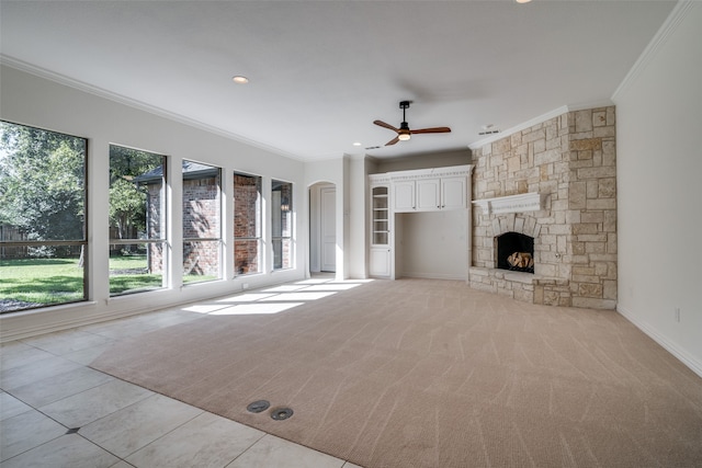 unfurnished living room with ornamental molding, light carpet, a fireplace, and ceiling fan