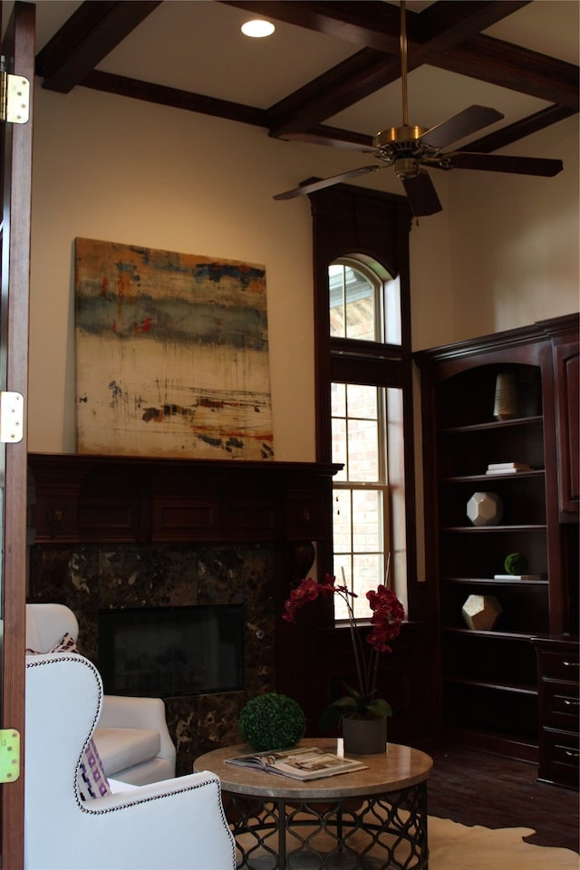 living room with beam ceiling, a healthy amount of sunlight, ceiling fan, and a high end fireplace