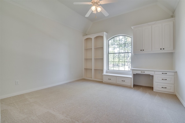 unfurnished office featuring ceiling fan, built in desk, vaulted ceiling, and light colored carpet