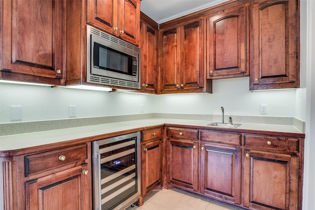 kitchen with sink, stainless steel microwave, light tile patterned floors, and wine cooler