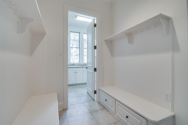 mudroom with sink and light tile patterned flooring