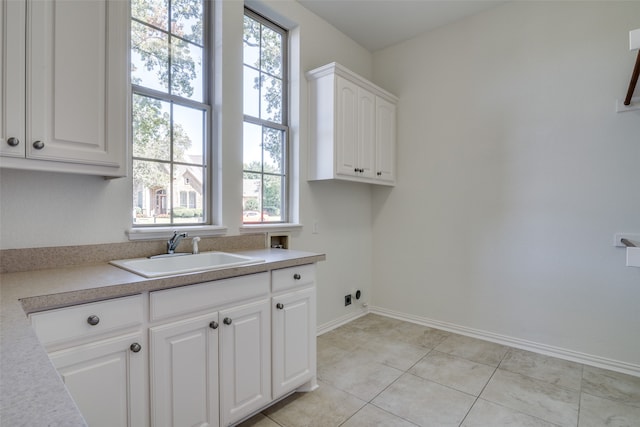 washroom featuring light tile patterned flooring, sink, electric dryer hookup, cabinets, and hookup for a washing machine