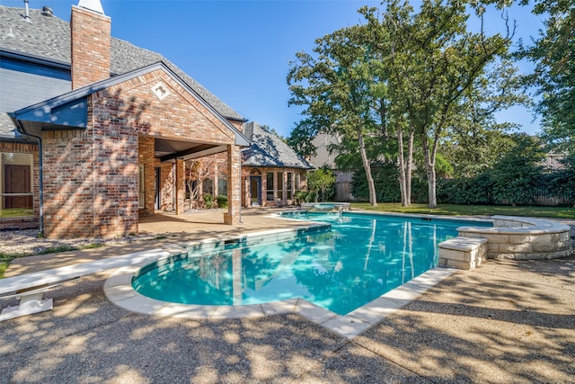 view of pool with a patio and an in ground hot tub