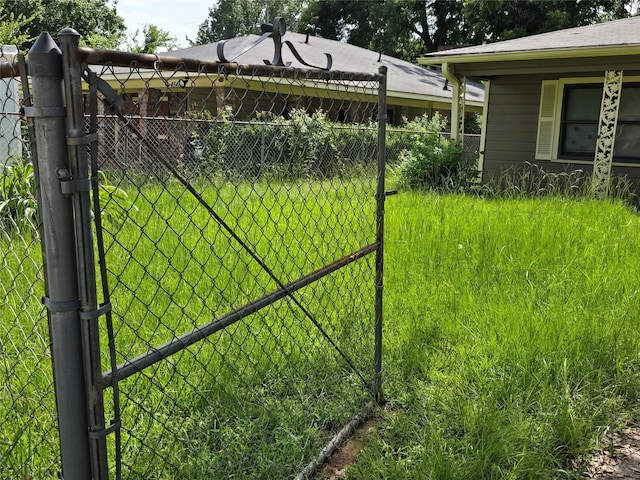 view of gate with a lawn