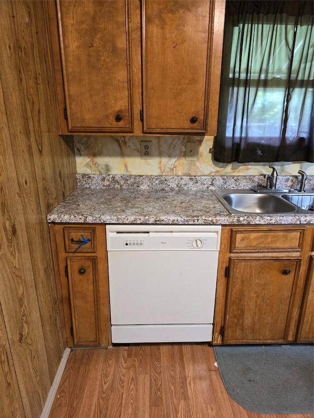 kitchen with sink, white dishwasher, and wood-type flooring