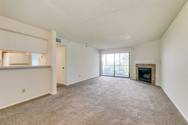 unfurnished living room featuring a fireplace, carpet flooring, and a textured ceiling