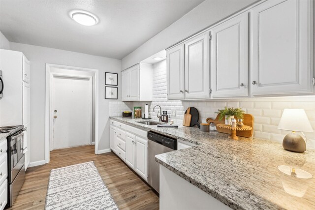 kitchen with white cabinetry, tasteful backsplash, light hardwood / wood-style floors, appliances with stainless steel finishes, and sink