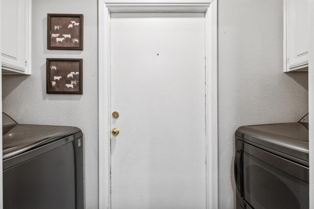 laundry room with washer and dryer and cabinets