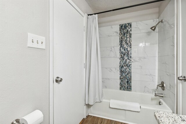 bathroom featuring shower / bathtub combination with curtain, a textured ceiling, and hardwood / wood-style flooring