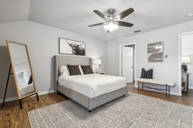 bedroom with a textured ceiling, wood-type flooring, ceiling fan, and lofted ceiling