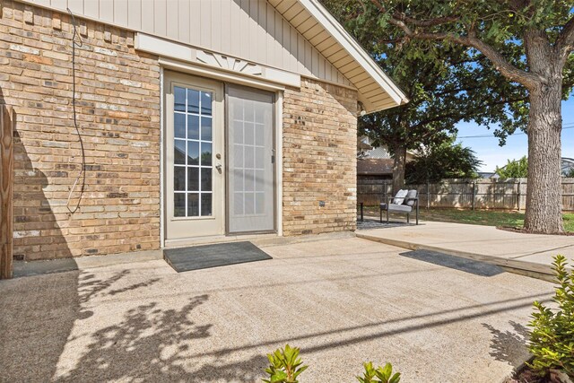 view of exterior entry featuring a patio area