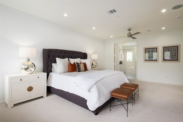 carpeted bedroom with ensuite bath and ceiling fan