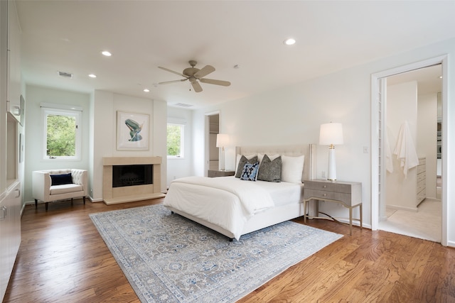 bedroom featuring multiple windows, wood-type flooring, and ceiling fan