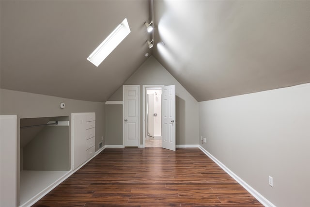 additional living space featuring lofted ceiling with skylight and wood-type flooring