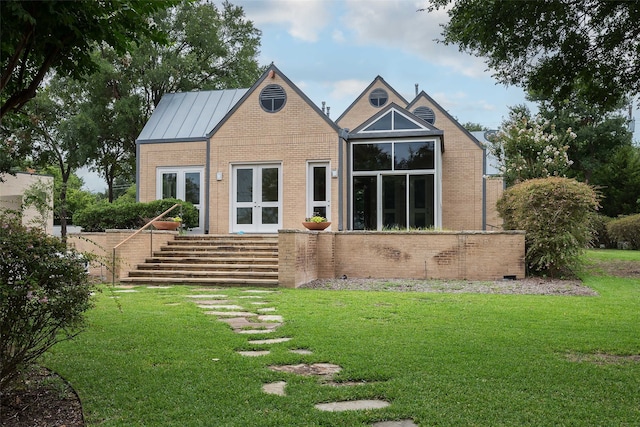 rear view of house with a lawn and french doors