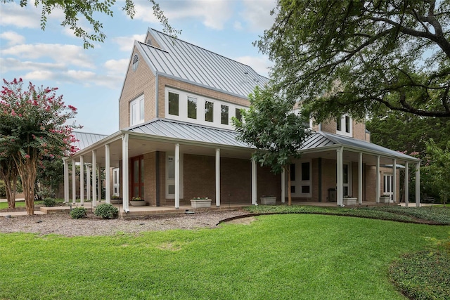 rear view of house featuring a porch and a yard