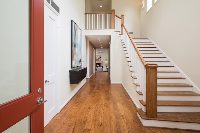 interior space with light hardwood / wood-style flooring and a towering ceiling