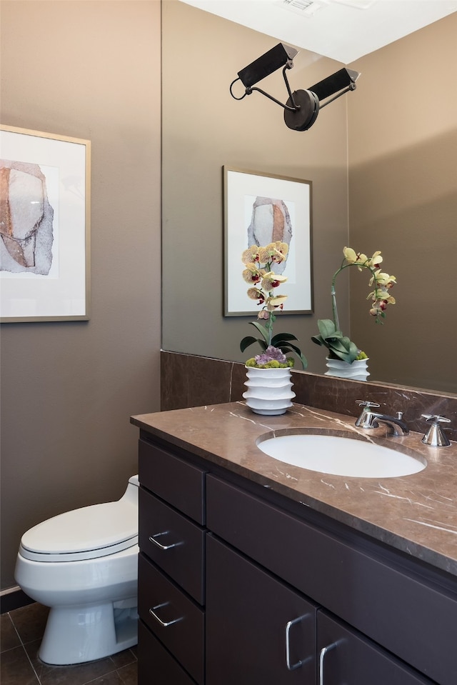 bathroom featuring tile patterned flooring, toilet, and vanity