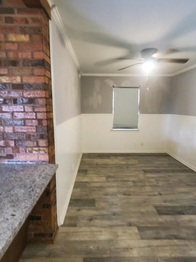 empty room featuring baseboards, wood finished floors, ornamental molding, and a ceiling fan