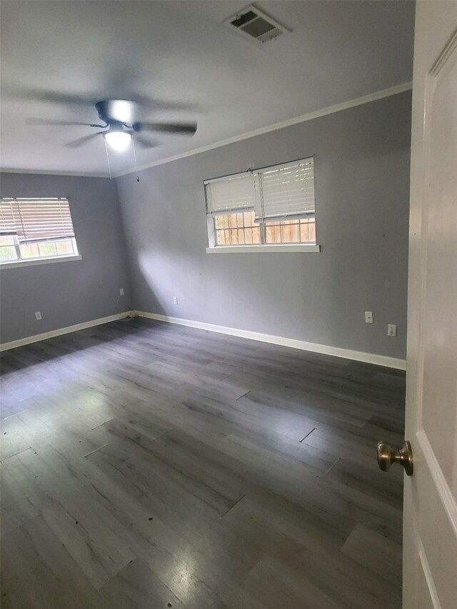 unfurnished room with baseboards, wood finished floors, visible vents, and ornamental molding