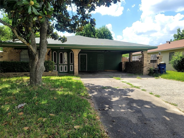 ranch-style house with brick siding, an attached carport, and driveway