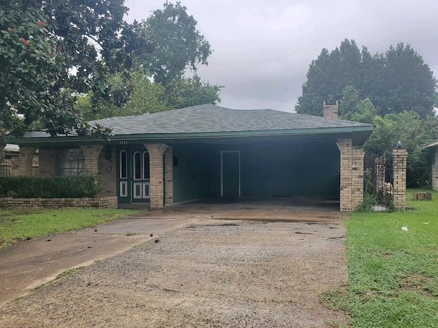 ranch-style home featuring brick siding, concrete driveway, a front lawn, and a shingled roof