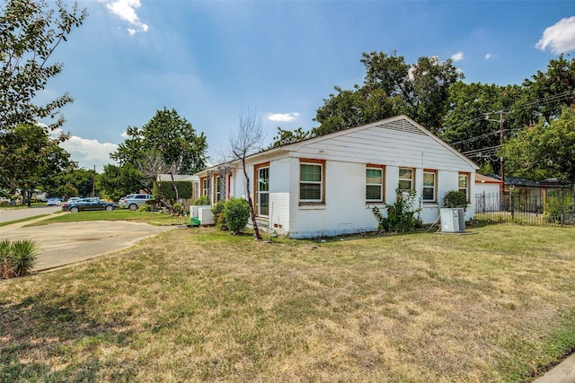 view of side of property with central AC unit and a lawn