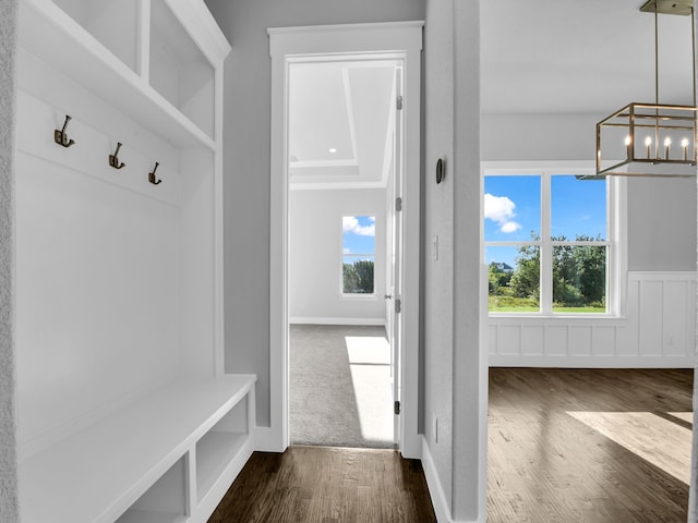 mudroom featuring a chandelier and dark wood-type flooring