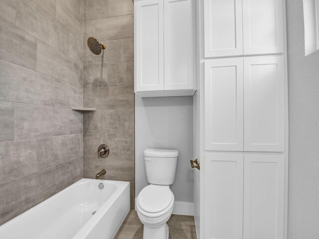 bathroom featuring tiled shower / bath combo and toilet