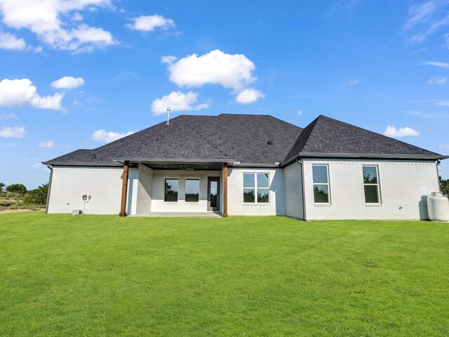 rear view of property with a lawn, ceiling fan, and a patio