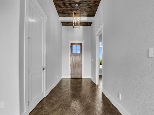 entryway with dark parquet flooring, wooden ceiling, and a chandelier