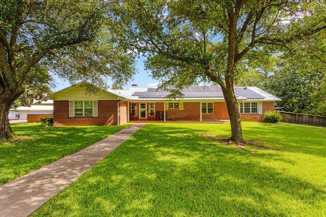 ranch-style house with a front lawn and solar panels