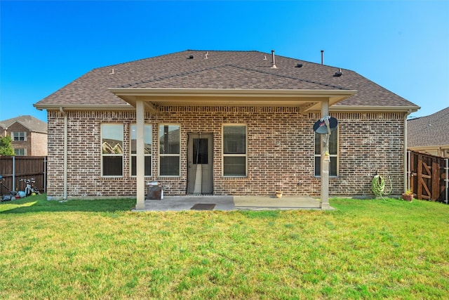 rear view of house with brick siding, a patio, and fence