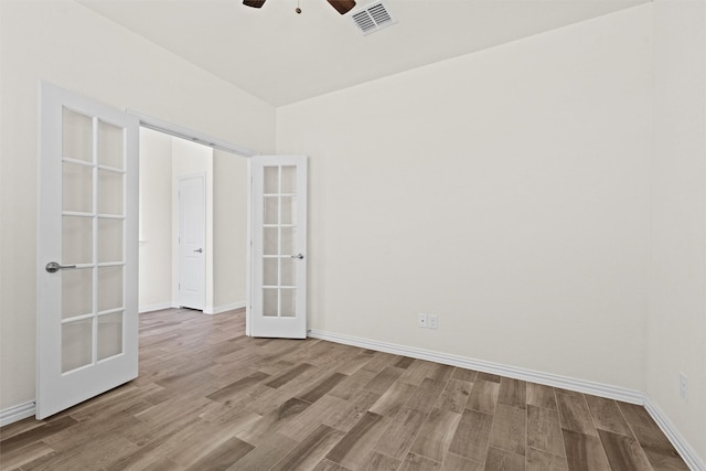 unfurnished room with baseboards, visible vents, a ceiling fan, light wood-style flooring, and french doors