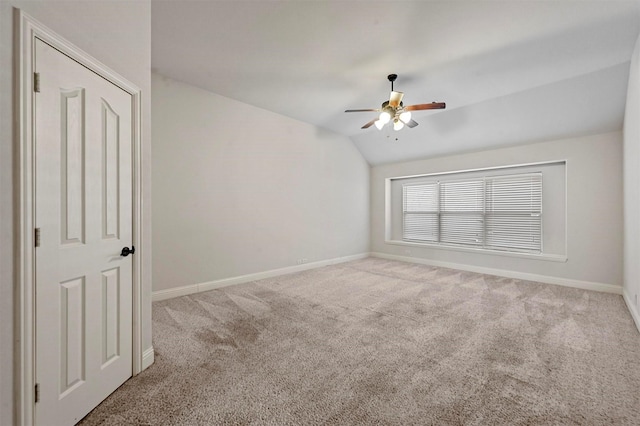 carpeted spare room featuring ceiling fan and vaulted ceiling