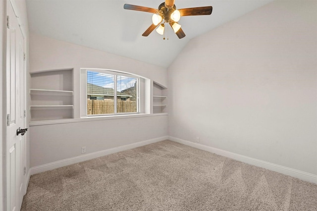 spare room featuring vaulted ceiling, carpet, and built in features