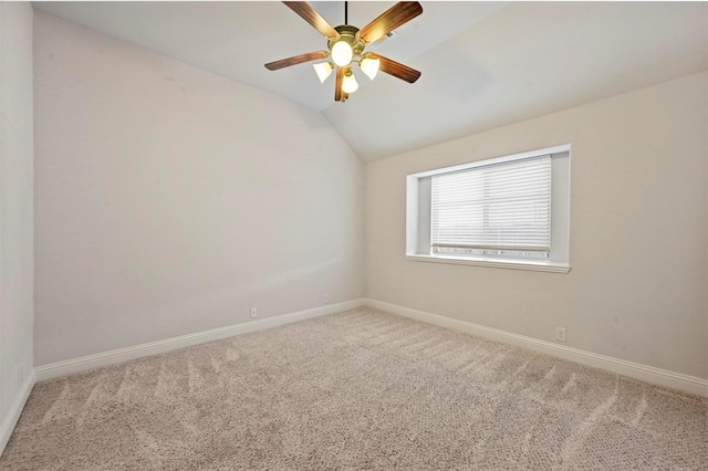 carpeted spare room with ceiling fan and vaulted ceiling