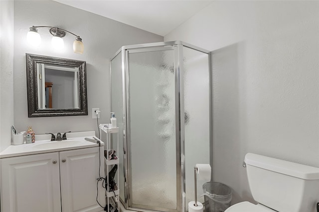 bathroom with a shower with shower door, vanity, and toilet