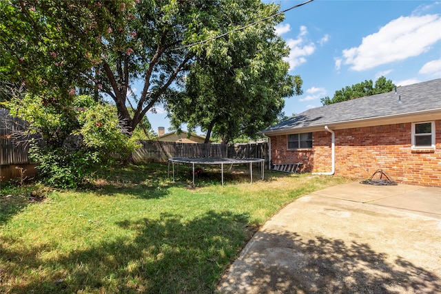 view of yard featuring a trampoline and a patio area