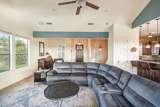 living room featuring ceiling fan, light tile patterned floors, and lofted ceiling