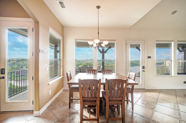 dining space featuring a wealth of natural light and an inviting chandelier