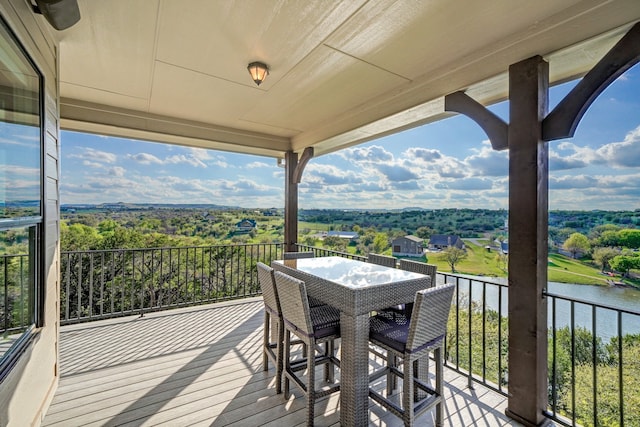 wooden deck featuring outdoor dining space and a water view