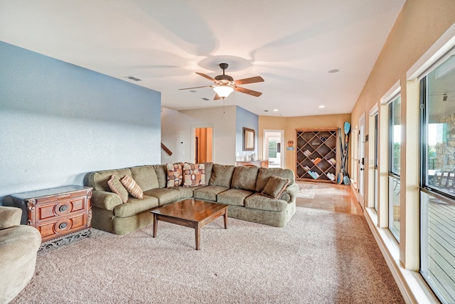 carpeted living room with ceiling fan